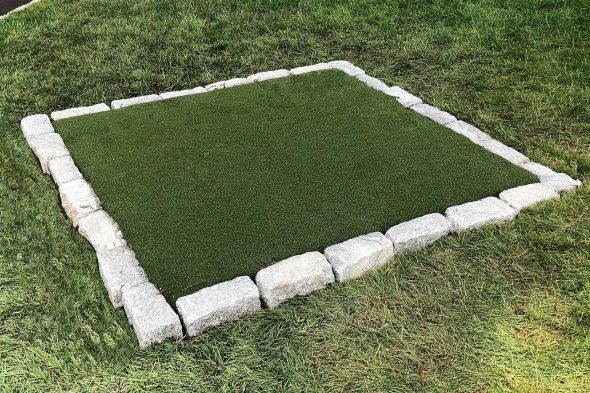 Augusta Tee box made of synthetic grass surrounded by stone border